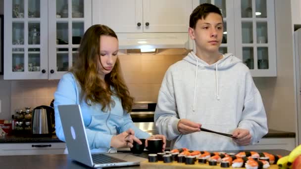 Веселий Хлопчик Підліток Дівчинка Дивиться Фільм Ноутбуках Їдять Суші Кухні — стокове відео