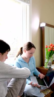 Ders çocuğu bilgisayardaki kızı gösteriyor. Arkadaşlarını inceliyor. Küçük kız kardeşi çevrimiçi öğreniyor. 