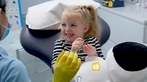年轻医生第一次去看牙医快乐的微笑愉快的交谈乳牙治疗护士金发碧眼的女婴牙科诊所最新技术 — 图库视频影像