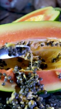 Yarım olgun papaya meyvesi ve tohum. Kokulu tropik meyve hamuru. Tatlı taze papaw, çiğ vejetaryen yemeği. Yüksek kaliteli FullHD görüntüler