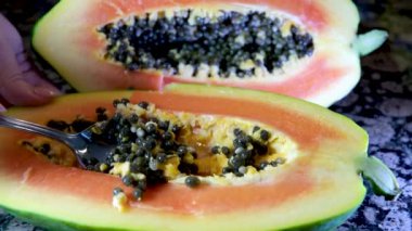 Yarım olgun papaya meyvesi ve tohum. Kokulu tropik meyve hamuru. Tatlı taze papaw, çiğ vejetaryen yemeği. Yüksek kaliteli FullHD görüntüler