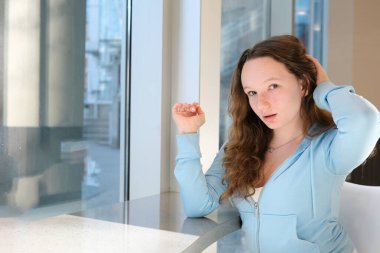 Sabah elinde bir fincan çay ya da kahve olan bir kadın uyanır ve evinin penceresinin yanında duran güneşin doğuşunu seyreder. Yüksek kalite fotoğraf