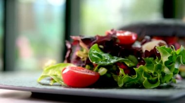 Mürekkepbalıklı, mürekkepli, çizburger sandviçli siyah ekmek. Pencere kenarında salata servis ediliyor. Lezzetli bulgogi, baharatlı bulgogi, ev yapımı, kalamar ekmekleri.