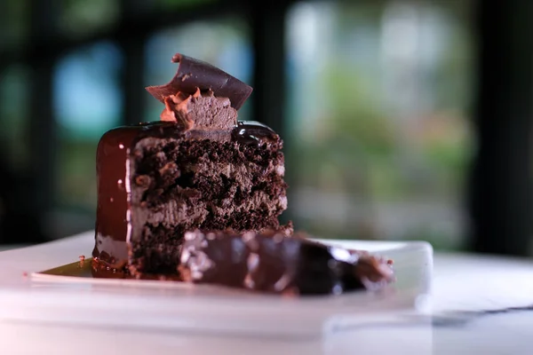 在一家高档餐馆的盘子里 站着一块精美的小巧克力蛋糕 上面有一片巧克力蛋糕 — 图库照片