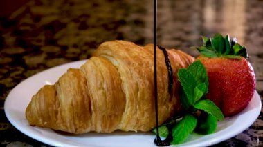 Kruvasanları pudra şekeri, çilek ve çilek şurubuyla kapat. Yüksek kalite 4k görüntü