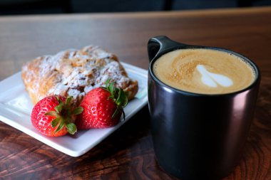 Beyaz tabakta kruvasan, kahve, portakal suyu ve omlet ile yakın plan Fransız kahvaltısı. Cappuchino ve kruvasan kafede