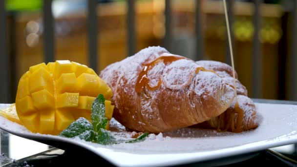 Nawadnianie Croissant Ciekłym Karmelem Białym Talerzu Liści Mango Mięty Pyszne — Wideo stockowe