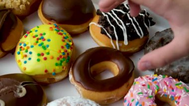 Lezzetli çöreklerin en güzel manzarası. İnsanlar kutudan donutları ahşap bir masa arkasından alıyorlar. Çocuk eli bir çörek alır.