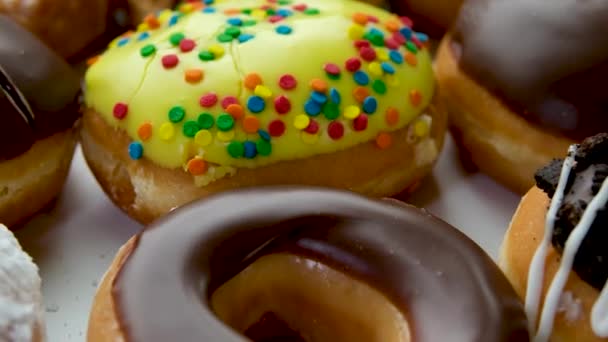特写的美味甜甜圈与洒水在桌子上分配不同口味的甜甜圈在一个盒子里 高质量的4K镜头 — 图库视频影像