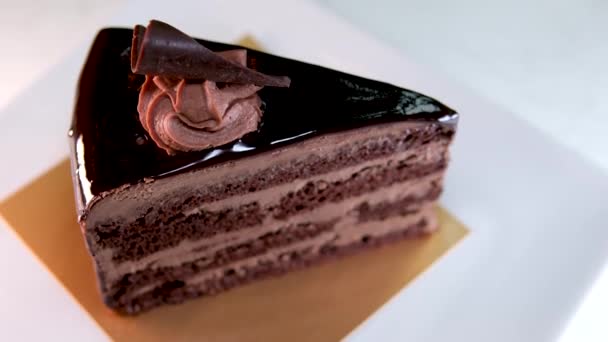 Een Stuk Chocoladetaart Met Chocoladecrème Een Wit Bord Hoge Kwaliteit — Stockvideo
