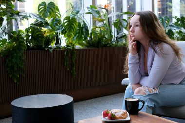 Yırtık kotlu genç bir kız üzgün bir kafede oturur zengin hayat her zaman mutlu değildir hüzün melankolik yalnızlık lezzetli yemekler tek başına kahve içmek çocukluk sarışının psikolojik sorunları