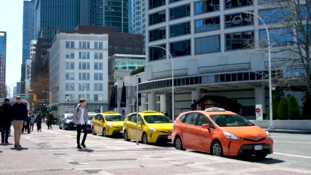 温哥华市一座大城市摩天大楼里的现实生活出租汽车黄色橙色行走的游客路过出租车2023年 — 图库视频影像
