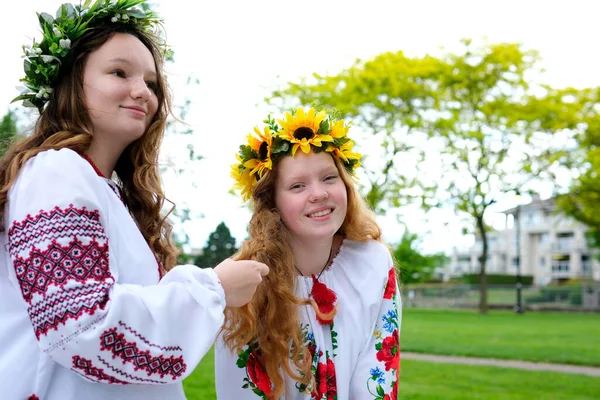 在乌克兰节日期间 年轻美丽的少女戴着花环与朋友交流 宣传乌克兰语的传统 在她头上戴一个花环编织辫子绣花衬衫 — 图库照片