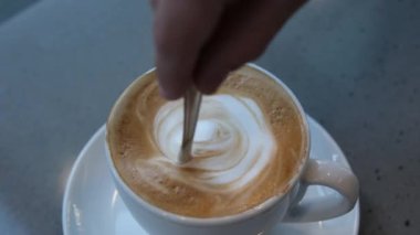 Kız kapuçino manzaralı bir kaşık dolusu şekeri engelliyor. Yüksek kalite 4k görüntü