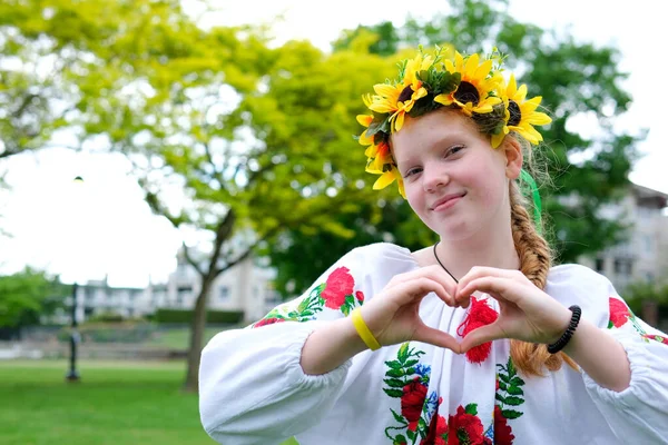 一位身穿绣花衬衫 头上戴着葵花花花环的乌克兰妇女在街上心情愉快 喜怒无常 红头发的娜迪兹达 — 图库照片