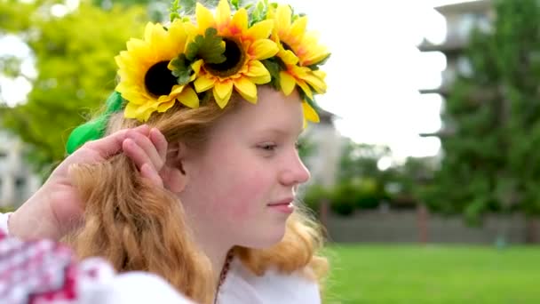 乌克兰人的一位朋友在街上唱着乌克兰的传统歌曲 她在头上编了一个花环 花环上挂着一朵向日葵 脸上挂着一个微笑的女人在唱着乌克兰的传统歌曲 — 图库视频影像