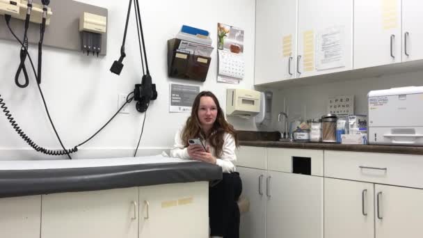 Κορίτσι Τηλέφωνο Κάθεται Στο Ιατρικό Γραφείο Στο Surrey Ραντεβού Γιατροί — Αρχείο Βίντεο