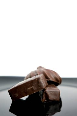 Beyaz arkaplanda izole edilmiş çikolatalı çikolata kübü reklamları yapmak yerine dikey leziz şekerler için siyah bir arka plan boşluğunda çikolatalar. Yüksek kalite