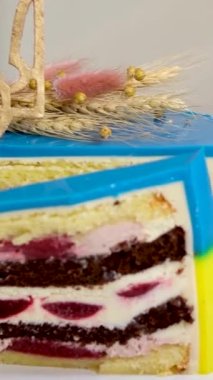 Ukrayna bayrağı şeklinde pasta. Sarı ve mavi katmanlı. Ukrayna arması, darı ve buğday başaklarıyla lezzetli bir pasta süslemesi.