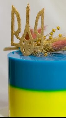 Ukrayna bayrağı şeklinde pasta. Sarı ve mavi katmanlı. Ukrayna arması, darı ve buğday başaklarıyla lezzetli bir pasta süslemesi.