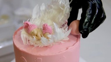 Aile için bir pasta süslemesi üzerinde melek kanatları ve pembe bebek bezli küçük bir çocuğun ayak izleri olan pembe pasta bir pasta yardımıyla çocuğun cinsiyetini nasıl öğrenilir?