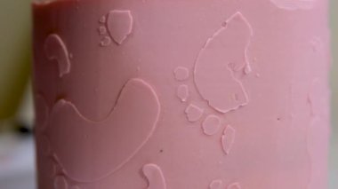 Aile için bir pasta süslemesi üzerinde melek kanatları ve pembe bebek bezli küçük bir çocuğun ayak izleri olan pembe pasta bir pasta yardımıyla çocuğun cinsiyetini nasıl öğrenilir?