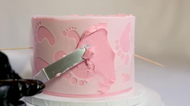 Dekoration Einer Torte Für Eine Familientaufe Rosa Kuchen Mit Fußabdrücken — Stockvideo