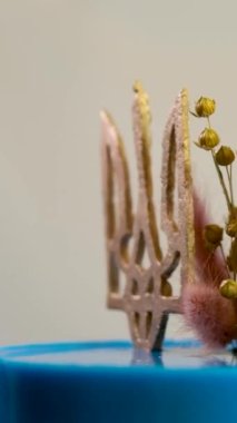 Ukrayna bayrağı şeklinde pasta. Sarı ve mavi katmanlı. Ukrayna arması, darı ve buğday başaklarıyla lezzetli bir pasta süslemesi.