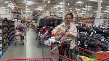 Costco toptan satış süpermarketi. İnsanlar alışveriş için büyük arabalara gidiyor. Kanada Vancouver BC 2023.