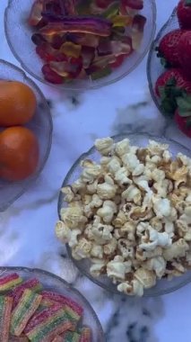 Doğada iki genç kız arkadaş pikniğe oturur kitapların elinde telefon ve portakal suyuyla sohbet eder.