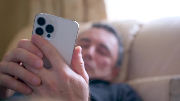 Homem Deitado Sofá Enquanto Olhava Para Telemóvel Sozinho Noite Imagens — Vídeo de Stock