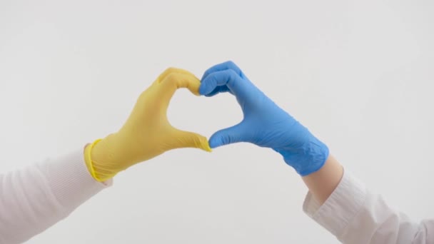 青い手袋の医者の手は 動作ランプの背景に心を作る 看護師はパンデミックの間の愛の兆候を示しています 医者は人を救う Govd コロナウイルス 高品質 — ストック動画