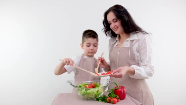 お母さんと小さな息子がチーズハニー朝食に広がる健康食品白背景ドリンクティーキッチンエプロン — ストック動画