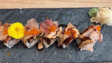 Black DRAGON ROLL Yengeç Eti, Avokado, Kappa Unagi, Avokado, Balık Gevreği ve Çiçekle süslenmiş Balık Restoranı