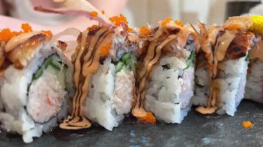 Black DRAGON ROLL Yengeç Eti, Avokado, Kappa Unagi, Avokado, Balık Gevreği ve Çiçekle süslenmiş Balık Restoranı