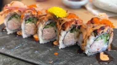 Black DRAGON ROLL Yengeç Eti, Avokado, Kappa Unagi, Avokado, Balık Gevreği ve Çiçekle süslenmiş Balık Restoranı