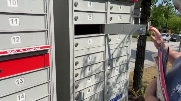 受信メールボックス手紙女性は 彼女がボックスを拾う配達とボックスからメールレッドキーでパッケージを受け取ったカナダバンクーバーサリー2023 — ストック動画