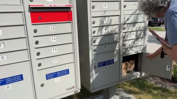 邮筒收件信女人收到包裹时 用红色钥匙从一个又一个邮筒到另一个邮筒 她拿起加拿大温哥华萨里2023号邮筒 — 图库视频影像