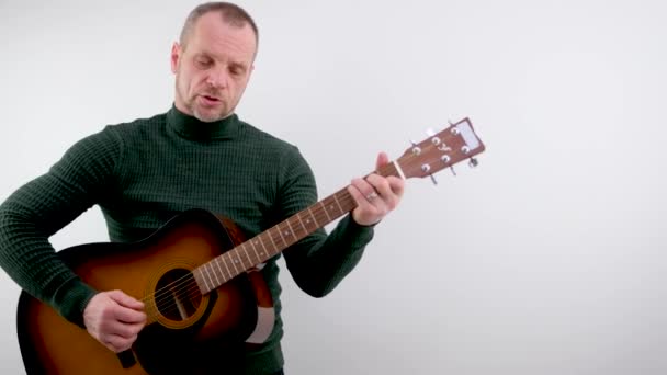 Улыбающийся Брюнетка Мужчина Играет Гитаре Белом Фоне Высококачественные Кадры — стоковое видео