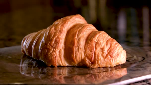 新鲜烤羊角面包让宏观视野更加清晰 法国羊角面包在黑色背景上旋转 新鲜而美味的法国早餐 高质量的4K镜头 — 图库视频影像