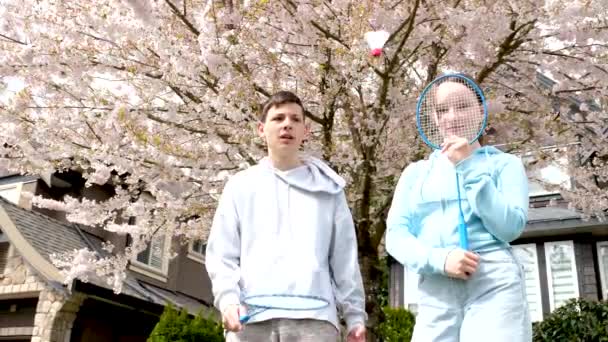 Dzieci Nastolatki Chłopcy Dziewczyna Grać Badminton Ulicy Przed Niebem Kwiaty — Wideo stockowe