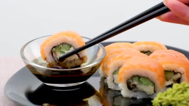 Philadelphia Sushi Black Plate Black Chopsticks Soy Sauce White Background — Vídeo de Stock