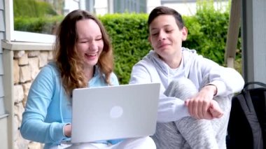 Samimi kahkahalar atan kızlar internetten film izliyorlar. Yüksek sesle gülüyorlar. Verandada oturan utangaç gençleri geri çeviriyorlar.