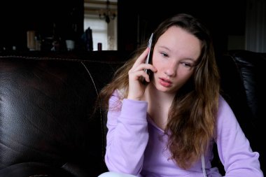 Gülümseyen genç iş kadını telefonda dizüstü bilgisayarla konuşuyor ofis masasında oturuyor, mutlu bayan müşteri internet sitesinden alışveriş siparişini onaylamak için cep telefonu görüşmesi yapıyor.