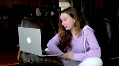 Cep telefonlu mutsuz Hintli genç kız kendini yalnız ve üzgün hissediyor, sanal ortamda kabadayılık taslıyor oturma odasında oturuyor. Stresli genç, internet istismarına maruz kalıyor