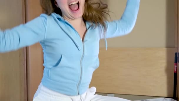有趣可爱的快乐小女孩跳上床唱歌可爱的美国小孩独自在卧室里听音乐跳舞开心地享受假装歌手的快乐 — 图库视频影像
