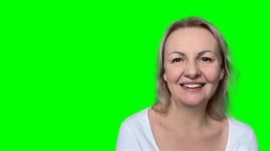 Kanepede oturan, arkadaşlarıyla görüntülü konuşma yapan, kafasından yakın plan fotoğraf çeken olgun sarışın kadın. Web kamerası görüntüsü gülüyor orta yaşlı kadın eğleniyor, yetişkin çocuklarla internette konuşuyor.