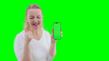 Yeşil ekran cep telefonu kromakey alanı olan yetişkin bir kadın. Gülüşmeler, gülüşmeler, sevinçler, el sallamalar. Tamam, telefona bak. 