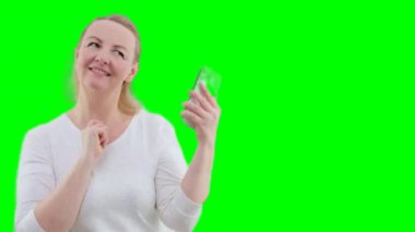 Güzel Yuong kadını beyaz arka planda dans ediyor, güzel dansçı. Beyaz bir arka planda elinde telefon dansı yapan bir kadın sevinç dolu bir yazı yazarak iyi haberler vererek iyi vakit geçiriyor.