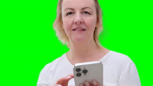 Närbild Kvinna Bläddra Igenom Sidorna Vit Telefon Mild Leende Medelåldern — Stockvideo